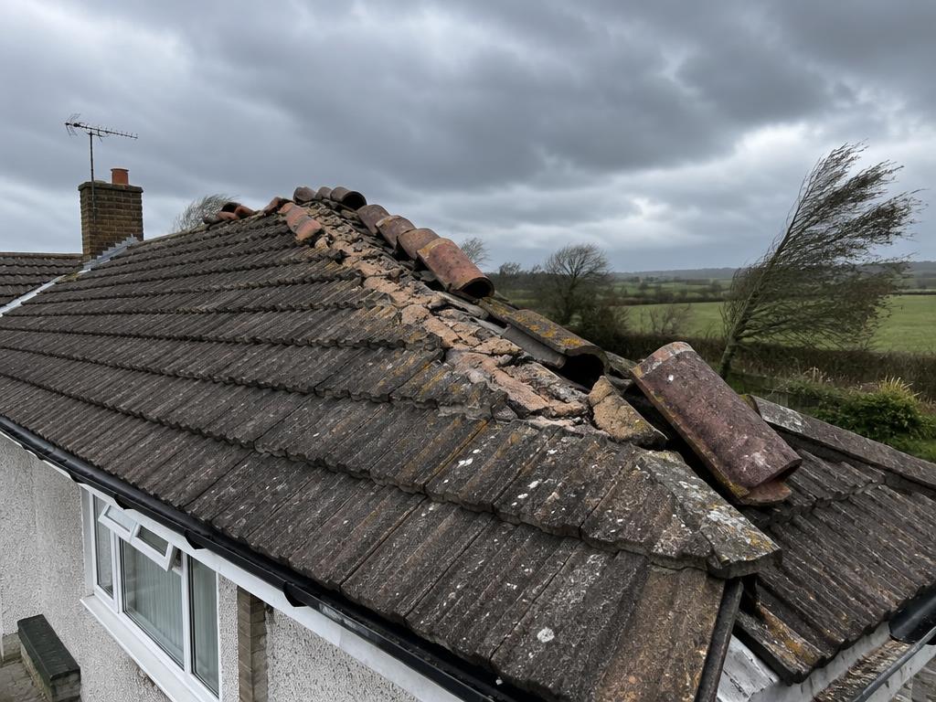 Illustrative example: storm-displaced ridge tiles and broken bedding mortar on an exposed bungalow roof